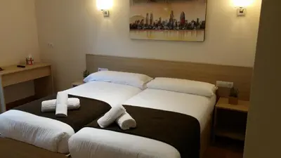 two beds in a hotel room with towels on them at Hostal Barcelona Travel in Barcelona