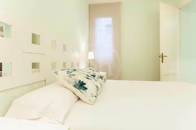 a white bedroom with a bed with a pillow on it at Apartamento para 4 Barcelona in Barcelona