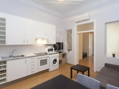 a kitchen and living room with a stove and a microwave at Gran Via Apartment in Barcelona