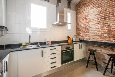 a kitchen with white cabinets and a brick wall at 43MAL1000-Nice&Bright 2BR flat next to Sagrada Familia in Barcelona