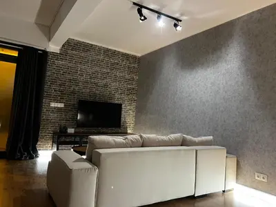 a living room with a white couch and a brick wall at Loft en Gracia in Barcelona