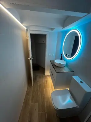 a bathroom with a white toilet and a mirror at Loft en Gracia in Barcelona
