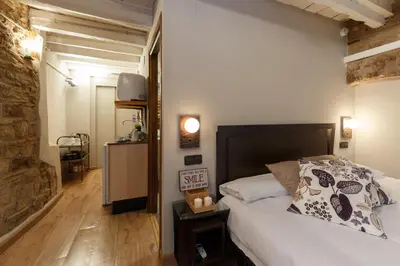 a bedroom with a white bed and a wooden floor at AinB Picasso-Corders Apartments in Barcelona