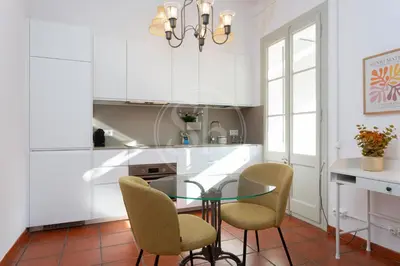 a kitchen with a glass table and chairs at Bonito apartamento en l'Eixample in Barcelona