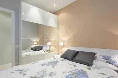a bedroom with a bed and a large mirror at Modern Eixample Apartment in Barcelona