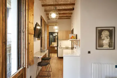 a kitchen with a bar and stools in a room at AinB Gothic-Jaume I Apartments in Barcelona