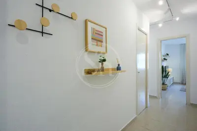 a hallway with a white wall with a shelf on it at Luminescent Valencia Apartment in Barcelona
