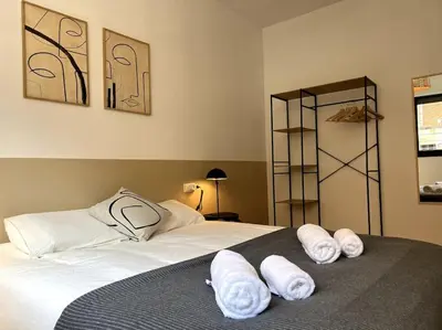 a bedroom with a bed with white towels on it at Apartamento entero con patio en Terrassa, Barcelona in Terrassa