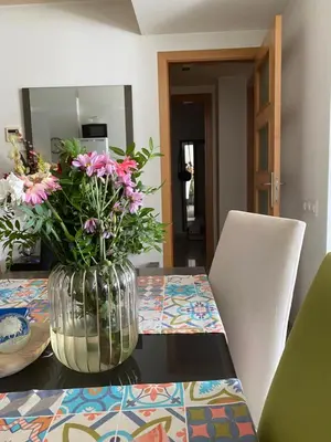 a vase filled with flowers sitting on a table at Piso cómodo Habitación in Sabadell