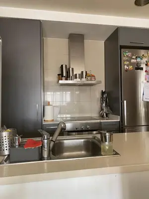 a kitchen with a sink and a stainless steel refrigerator at Piso cómodo Habitación in Sabadell