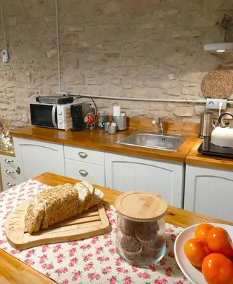 a kitchen with a table with a cutting board and bread at La Julita in San Quírico Safaja