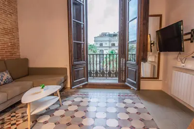 a living room with a couch and a large window at Barcelona Classic Plaza Real Apartments in Barcelona