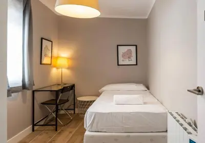 a small room with a bed and a table at BeBarceloner Vall Hebron Apartment in Barcelona