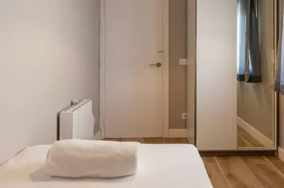 a white bed with a towel on it in a room at BeBarceloner Vall Hebron Apartment in Barcelona