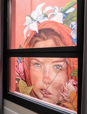 a window with a painting of a woman at Aerohotel Barcelona Airport 24h in El Prat de Llobregat