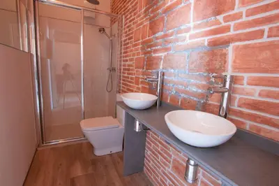 a bathroom with two sinks and a brick wall at Barcelona Classic Catedral Apartments in Barcelona