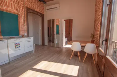 a kitchen with two white chairs and a table at Barcelona Classic Catedral Apartments in Barcelona