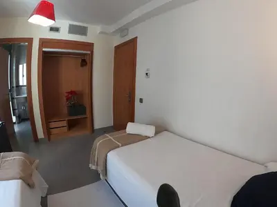 a bedroom with a white bed and a red light at Sitges rooms by Sitges Apartment in Sitges