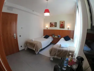 a small room with two beds and a window at Sitges rooms by Sitges Apartment in Sitges