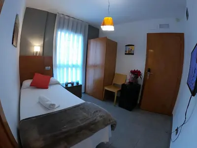 a bedroom with a bed with a red pillow at Sitges rooms by Sitges Apartment in Sitges