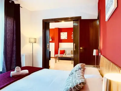 a bedroom with a bed and a red wall at La Pedrera Residence in Barcelona