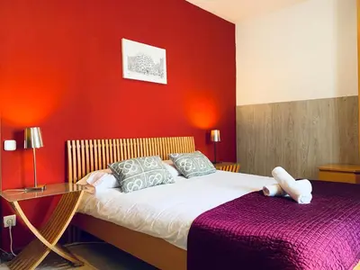 a bedroom with a bed and a red wall at La Pedrera Residence in Barcelona