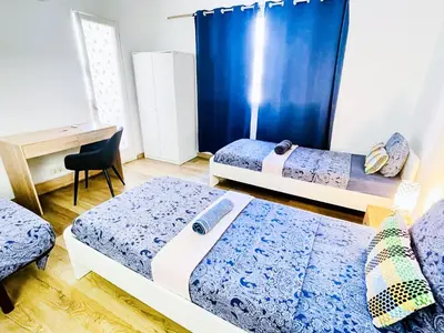 a room with two beds and a desk and a desk at Centric Rooms Ghotic in Barcelona