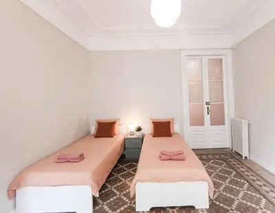 two beds in a white room with pink sheets at Centric Rooms Ghotic in Barcelona