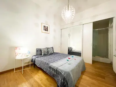 a bedroom with a bed and a chandelier at Centric Rooms Ghotic in Barcelona