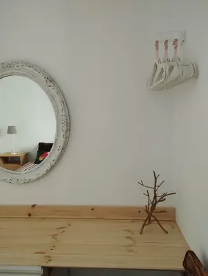 a mirror on a wall next to a wooden table at Apartment Barca 1 Camp Nou in Hospitalet de Llobregat