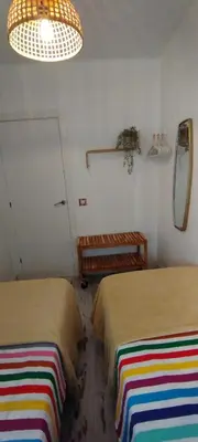 a room with two beds and a table and a mirror at Apartment Barca 1 Camp Nou in Hospitalet de Llobregat
