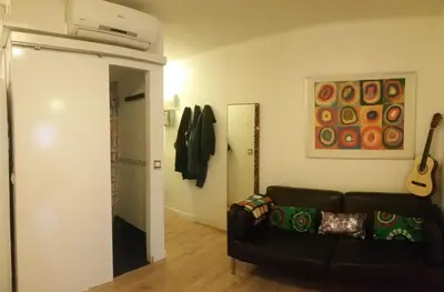 a living room with a couch and a guitar on the wall at Apartment Barca 1 Camp Nou in Hospitalet de Llobregat