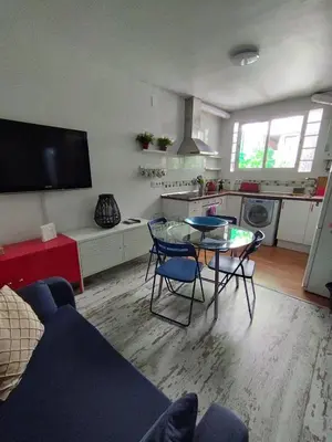 a living room with a table and chairs and a kitchen at Apartment Barca 1 Camp Nou in Hospitalet de Llobregat