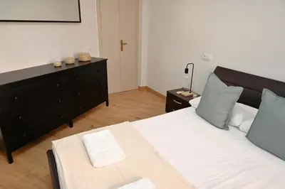 a bedroom with a large bed and a dresser at Homenfun Barcelona Alfonso X in Barcelona