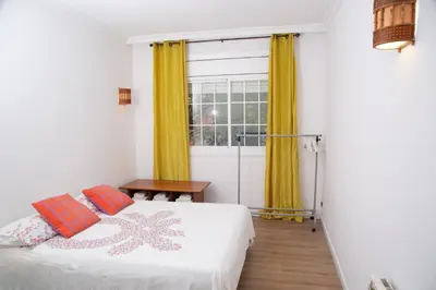 a bedroom with a bed and a window with yellow curtains at GranVia Fira Apartment in Hospitalet de Llobregat