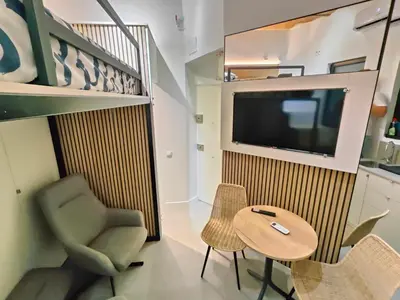a living room with a table and a chair and a tv at Moderno estudio Sagrada Familia in Barcelona