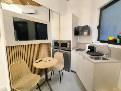 a small kitchen with a sink and a table and chairs at Moderno estudio Sagrada Familia in Barcelona