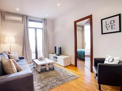 a living room with a couch and a tv and a mirror at Apartment in Barcelona near the Beach in Barcelona