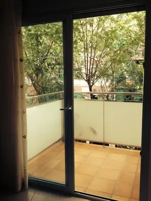 an open glass door to a balcony with trees at Apartamentos Navas 2 in Barcelona