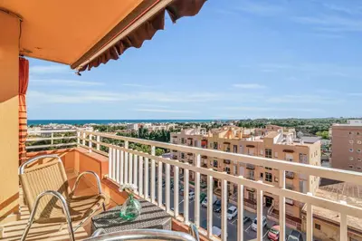 a balcony with chairs and a view of a city at Sea View Penthouse in Vilanova i la Geltrú
