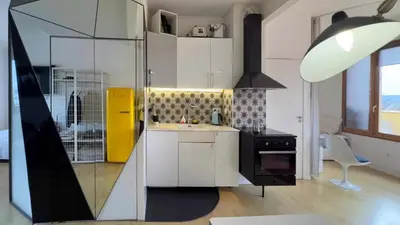 a kitchen with white cabinets and a yellow stove at Atico Central con Terraza in Barcelona