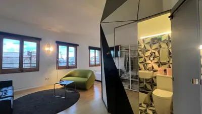 a living room with a green chair and a mirror at Atico Central con Terraza in Barcelona