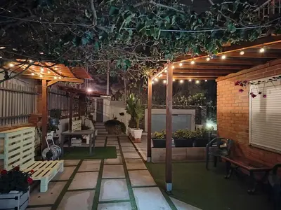 a pergola with lights on a patio at night at Vila Peña Private Apartment with Shared Pool & Gardens in Cubelles
