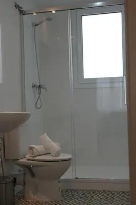 a bathroom with a shower and a toilet and a window at RIUS33 - Huge & Spacious Apartment in Montjuic in Barcelona
