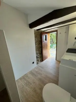 a bathroom with a toilet in a room with a hallway at Casa Rural CAL PAGÉS Montseny in Montseny