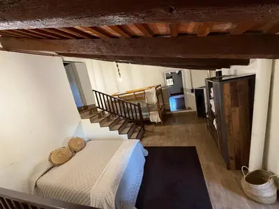 a bedroom with a bed and a staircase in a room at Casa Rural CAL PAGÉS Montseny in Montseny