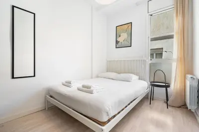 a kitchen with white cabinets and a table and chairs at Joan Blanques Apartment in Barcelona