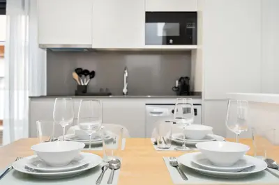 a dining room table with plates and bowls and wine glasses at Fira Building in Hospitalet de Llobregat