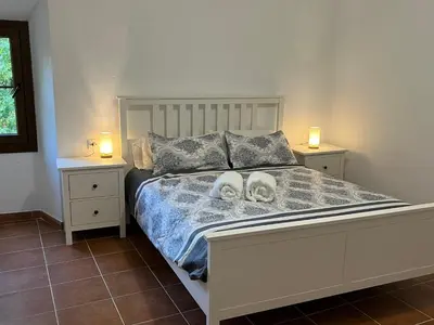 a bedroom with a white bed with two dogs on it at Casa Rural Can Ricós - El Mirador del Montseny in Vallgorguina