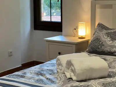 a bedroom with a bed with a lamp and a window at Casa Rural Can Ricós - El Mirador del Montseny in Vallgorguina